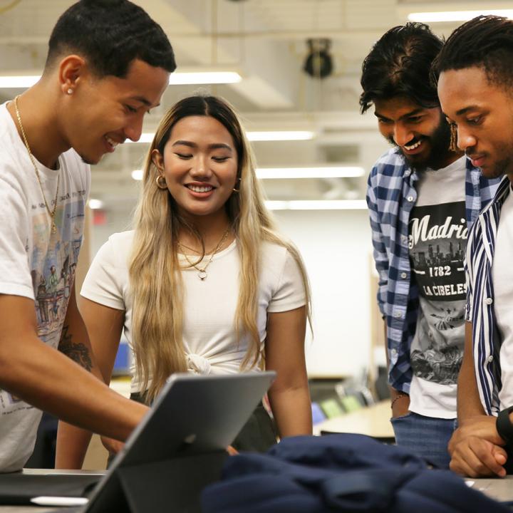 Students smiling over a laptop