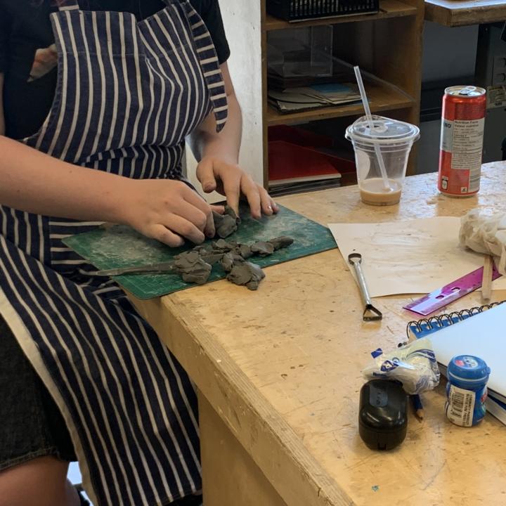 student sculpting with clay