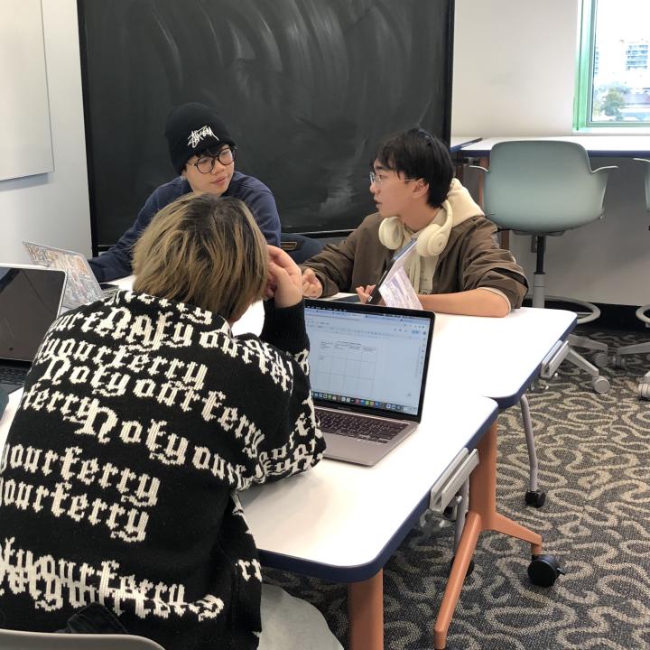Three EAD students chatting at a table.