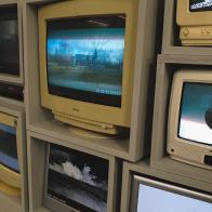 CRT televisions stacked upon one another, showing various abstracted images. 