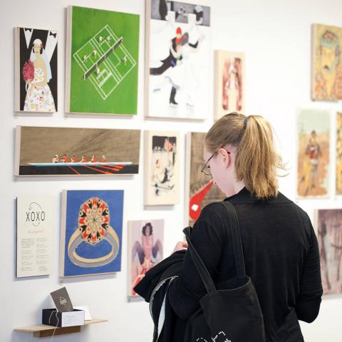 Girl at Graduate Exhibition looking at work